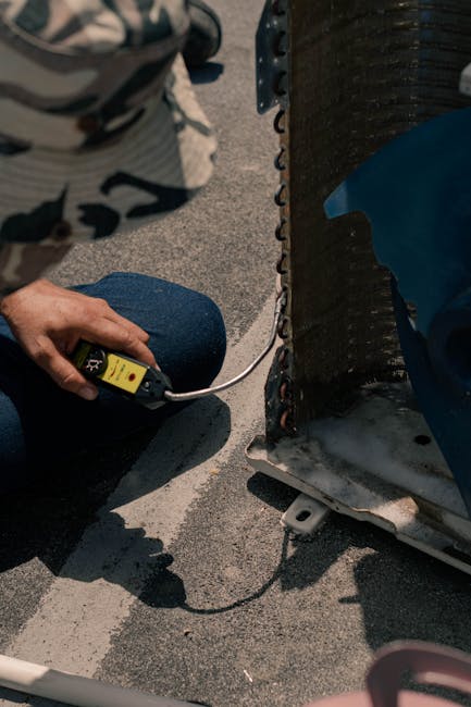 pexels-photo-5463582-5463582 Close-up of a technician working on an air conditioning unit with tools on a sunny day.